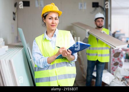 Smiling female civil engineer with documents at construction site Stock Photo