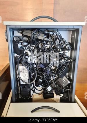 various charging cables and adapters in a drawer Stock Photo