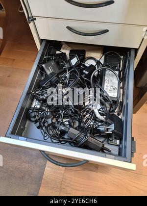 various charging cables and adapters in a drawer Stock Photo