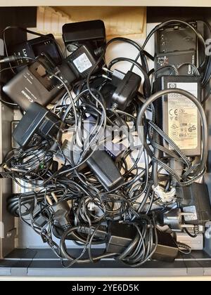 various charging cables and adapters in a drawer Stock Photo