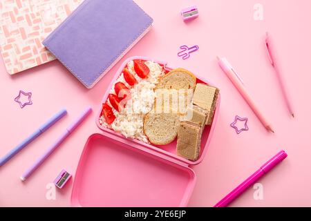 Lunchbox with delicious food and different stationery on pink background Stock Photo