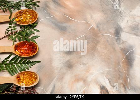Wooden spoons with different pills and fresh plants on grunge background Stock Photo