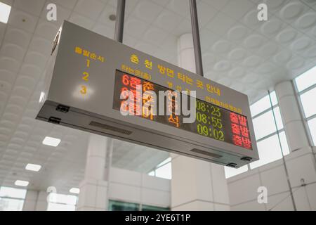 Large electronic sign with a foreign language on it. The sign is displaying the time and the number of people in the building Stock Photo