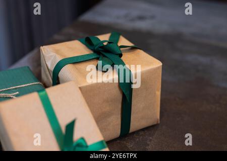 Gift boxes wrapped with green ribbons on table, ready for Christmas celebration, at home Stock Photo