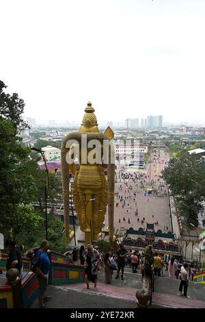 View of giant statue of Lord Murugan overlooking the open courtyard at Sri Subramaniar Swamy temple from steps leading up into the Batu Caves complex Stock Photo