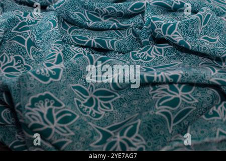 A piece of fabric with a floral pattern. The fabric is green and white. The pattern is very detailed Stock Photo