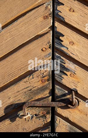 Rusty old hook latch on wooden door exterior Stock Photo