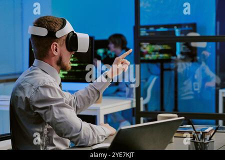 Man In VR Headset Working In Modern IT Office Stock Photo