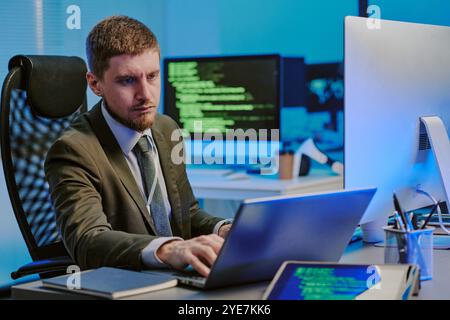 Young Man Working On Laptop In Data Security Office Stock Photo