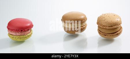 Three differently coloured macarons in front of a white background, studio shot Stock Photo
