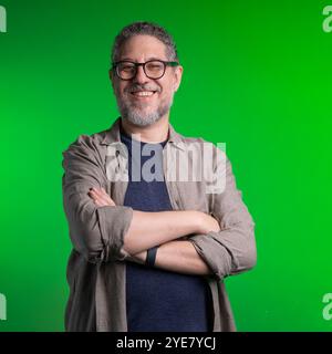 Portrait of friendly mature businessman on chroma key background. Middle aged professional with grey beard and glasses looking at camera with confiden Stock Photo
