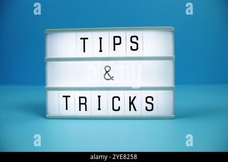 Tips & Tricks letterboard text on LED Lightbox on blue background Stock Photo