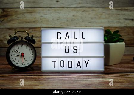CALL US TODAY letterboard text on LED Lightbox on wooden background, Business and Communication concept background Stock Photo