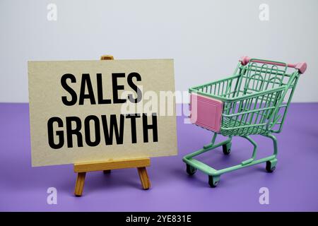 Sales Growth text message and trolley shopping cart on purple background Stock Photo