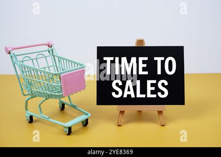 Time To Sales text message and trolley shopping cart on yellow background Stock Photo