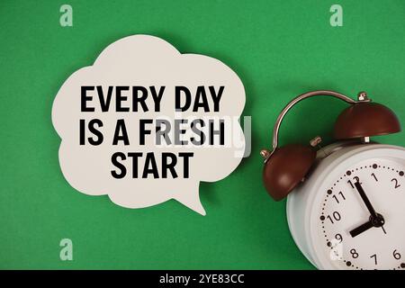 Every Day Is A Fresh Start text on speech bubble with alarm clock on green background Stock Photo