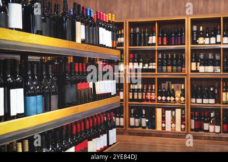 Liquor store background. Alcohol retail industry. Wine bottles on shelves in wine shop. Stock Photo