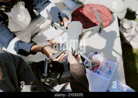 High angle shot of unrecognizable girls hand holding graphite drone while unrecognizable boy repairing it Stock Photo