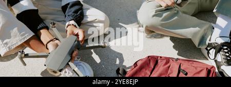 Website banner with two unrecognizable boy repairing black drone together outside Stock Photo