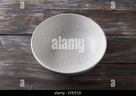 Simple empty light gray ceramic bowl on wooden table, rustic style, top view, mockup, for graphic design, creativity. Stock Photo