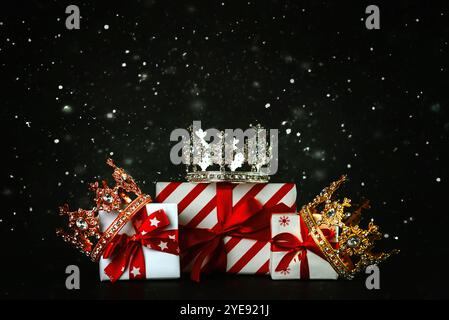 Crowns of the three wise men with Christmas gift boxes and snowflakes on a dark background. Concept for Dia de Reyes Magos day. Three Wise Men Stock Photo