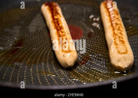 Bavaria, Germany - October 30, 2024: Vegan bratwurst is fried until crispy in the pan *** Vegane Bratwurst wird in der Pfanne knusprig angebraten Stock Photo