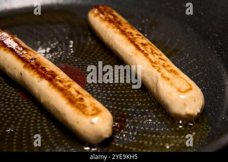 Bavaria, Germany - October 30, 2024: Vegan bratwurst is fried until crispy in the pan *** Vegane Bratwurst wird in der Pfanne knusprig angebraten Stock Photo