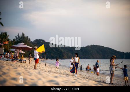 Tourists enjoying beautiful Pantai Tengah (beach) at sunset in Malaysia; Langkawi, Malaysia Stock Photo