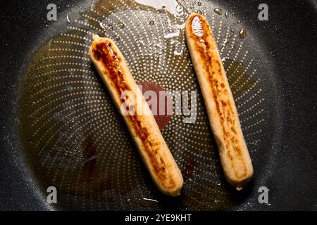 Bavaria, Germany - October 30, 2024: Vegan bratwurst is fried until crispy in the pan *** Vegane Bratwurst wird in der Pfanne knusprig angebraten Stock Photo