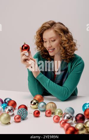 A cheerful young woman in a green cardigan posing and smiling. Stock Photo