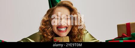 A young woman wearing festive clothing smiles brightly while posing. Stock Photo