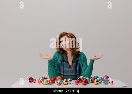 A young woman with curly hair is cheerfully posing cheerfully surrounded by vibrant ornaments. Stock Photo