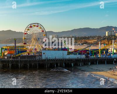 The Santa Monica Beach Pier in California, with Pacific Park at Sunset from a UAV Drone View showing the City Lights Stock Photo