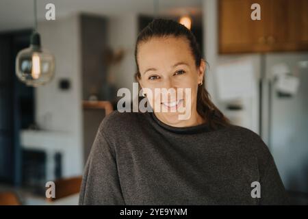 Portrait of smiling mature woman in casuals at home Stock Photo