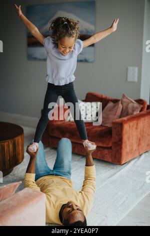 High angle view of daughter playing with father lying on carpet at home Stock Photo