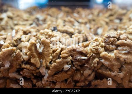 Walnut background. Peeled walnuts on display at a grocery store. Closeup view on shelled walnuts selling by weight in food store. Stock Photo