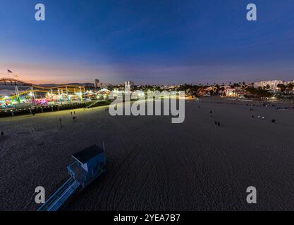 The Santa Monica Beach Pier in California, with Pacific Park at Sunset from a UAV Drone View showing tthe City Waterfront Area from a Drone. Stock Photo