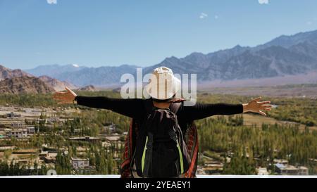 Lady tourist enjoying the scenic view of mountains spreading her hands out. Excited and Mesmerised Stock Photo