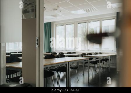 Chairs arranged at desk in empty classroom Stock Photo