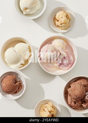 different ice cream bowls on sunny white table, top view Stock Photo