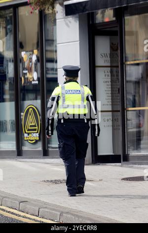 single female garda officer on foot patrol in letterkenny, county donegal, republic of ireland Stock Photo