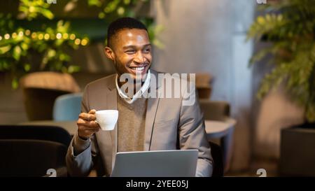Afro manager drinking tea and using personal computer Stock Photo