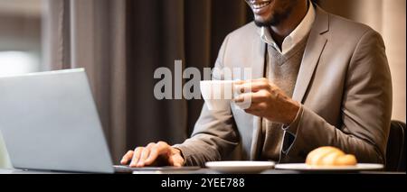 Afro manager drinking tea and using pc Stock Photo