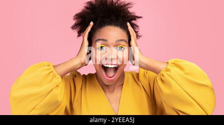 Happy afro woman screaming and grabbing her head Stock Photo
