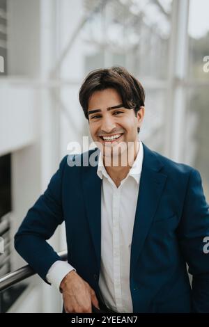 Portrait of happy young businessman standing by railing Stock Photo