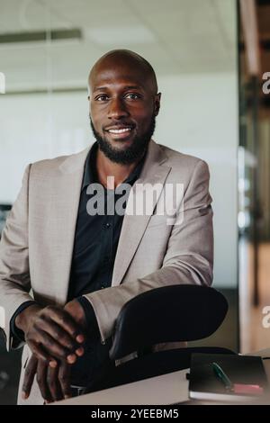 Portrait of smiling businessman leaning on office chair Stock Photo