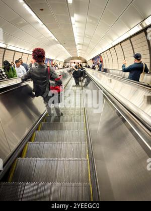 looking down on People riding an escalator inside a busy new york underground subway station, with commuters  in manhattan nyc usa Stock Photo
