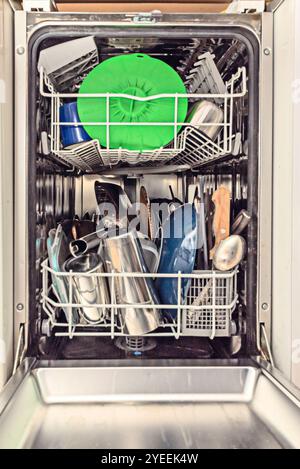 The operation of a dishwasher is based on an automated wash cycle that combines hot water, detergent and mechanical action to remove dirt and food res Stock Photo