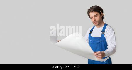 Professional Foreman Wearing Uniform Checking Construction Draft Over Light Studio Background Stock Photo