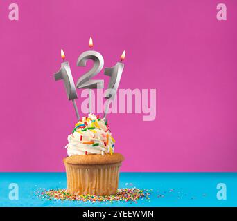 Cupcake with birthday candle number 121 - Anniversary card on blue and violet background Stock Photo